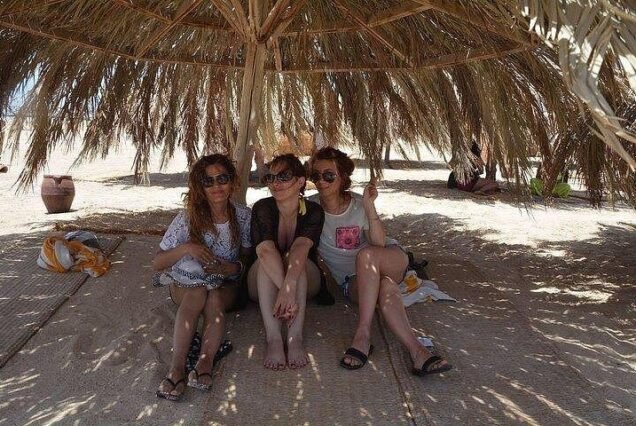 Happy couple relaxing on the white beach of Hula Hula Island Red Sea.