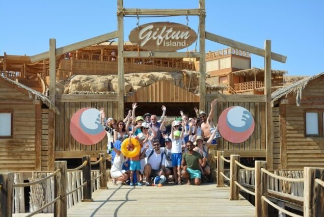A group of happy tourists taking a souvenir photo on Orange Bay Hurghada beach
