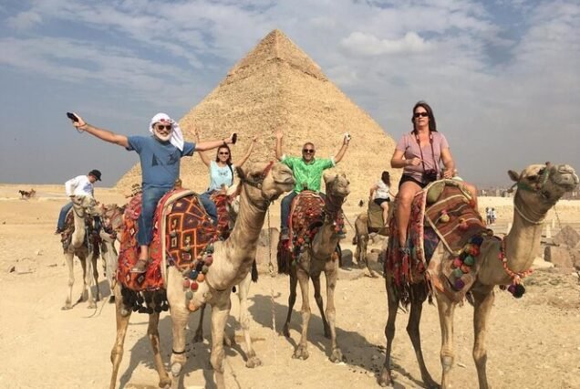 A private group enjoying a Cairo VIP Tour in front of the Great Pyramids of Giza.